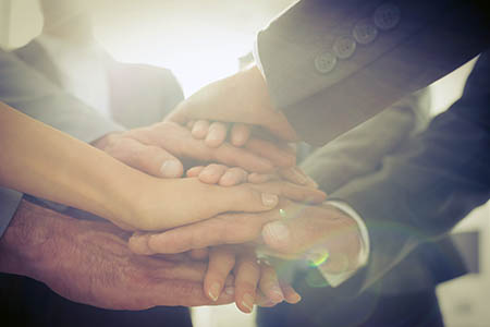 Many hands placed one on top of the other.