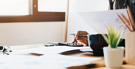 Researcher analysing data using a calculator.
